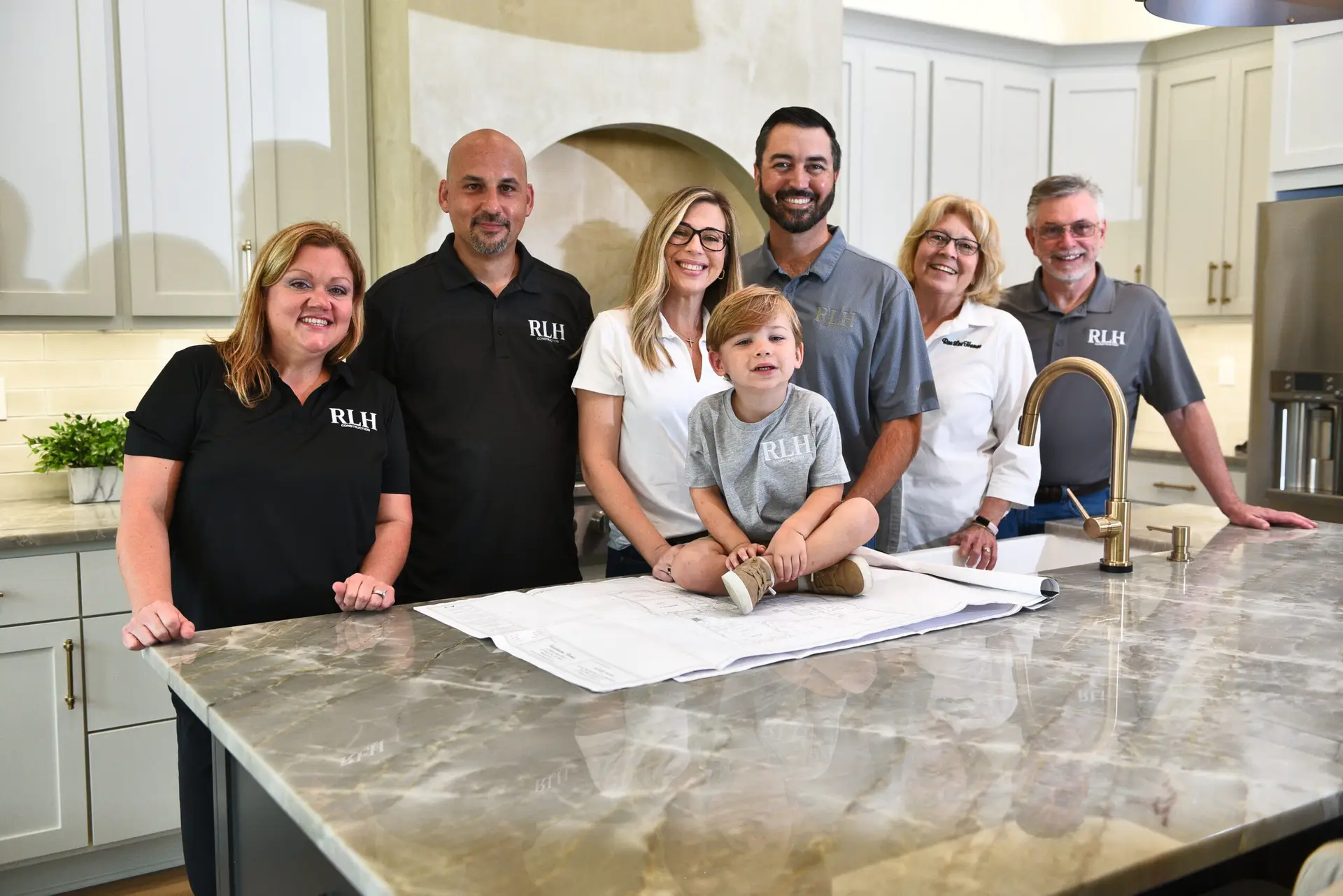 RLH Construction team meeting in a custom home kitchen in Covington
