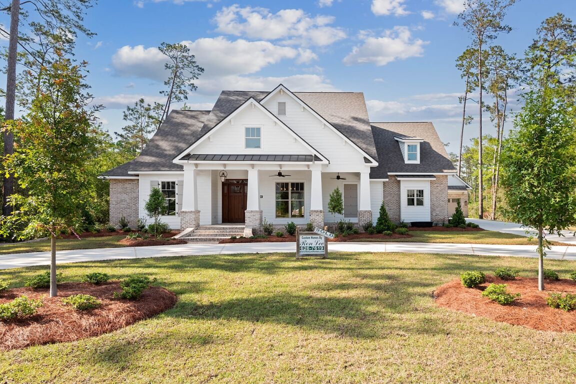 Custom-built home with front porch, landscaped yard, and traditional exterior